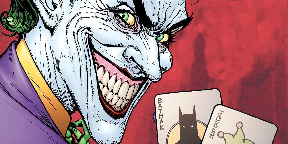 El Joker sonriendo y sosteniendo dos naipes en DC Comics