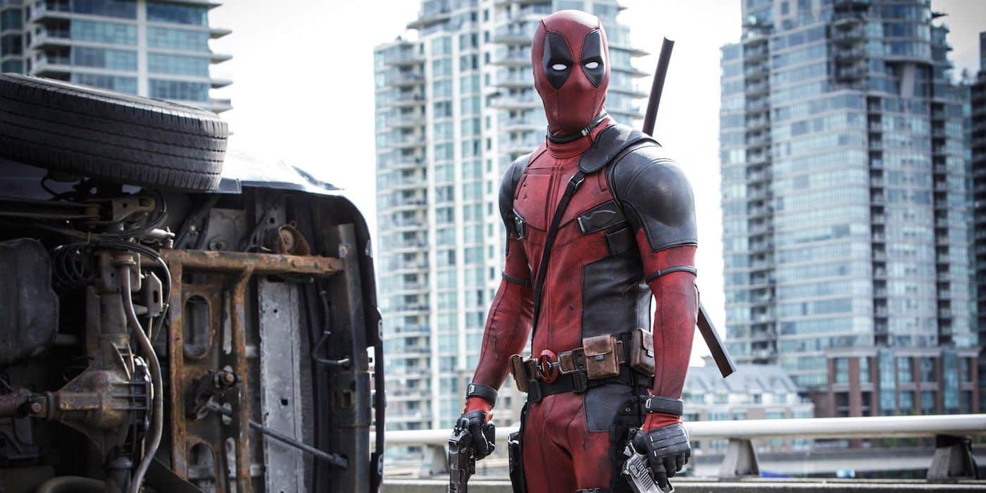 Deadpool parado en la ciudad sosteniendo un arma