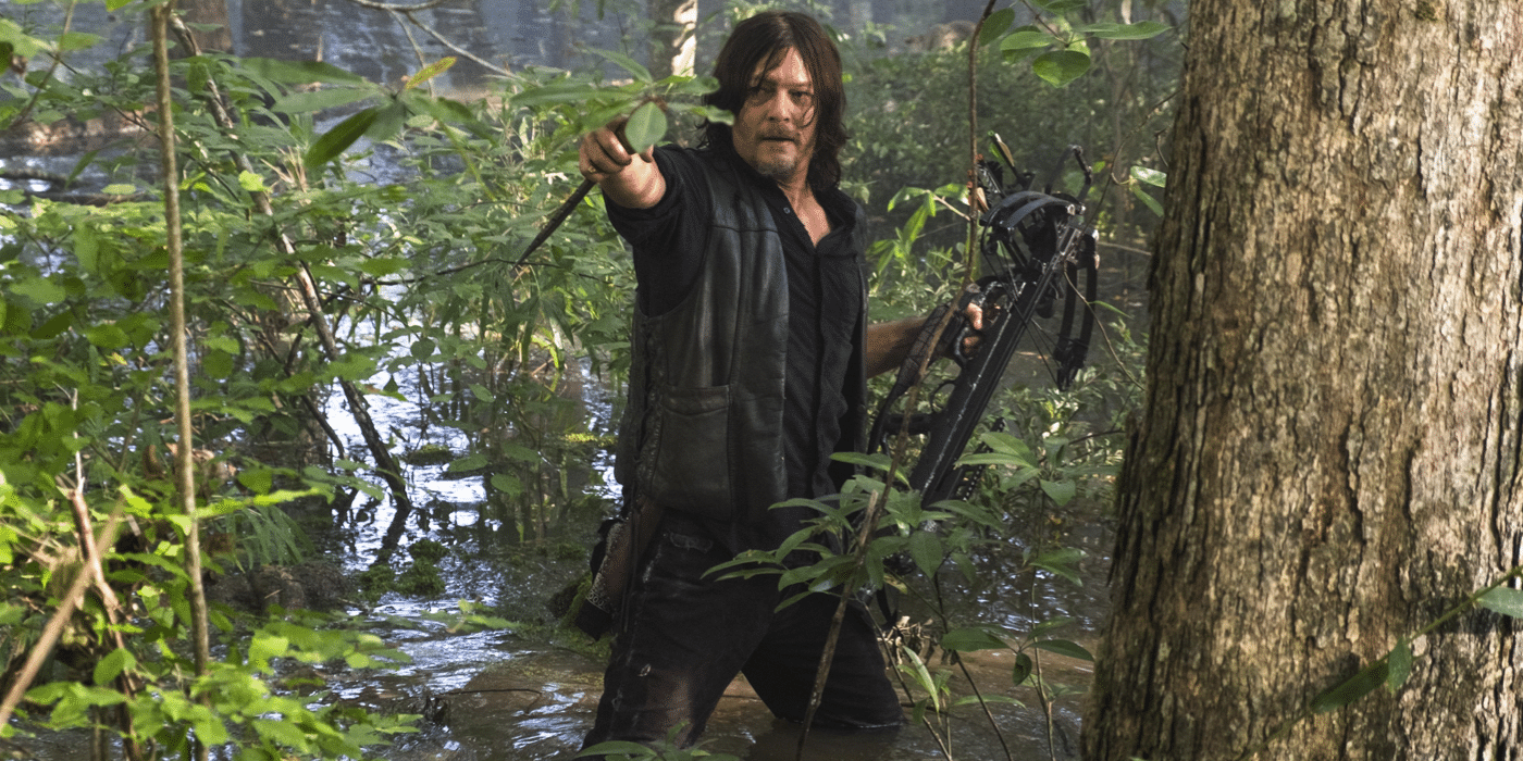 Daryl Dixon (Norman Reedus) apuntando hacia adelante en un pantano en The Walking Dead