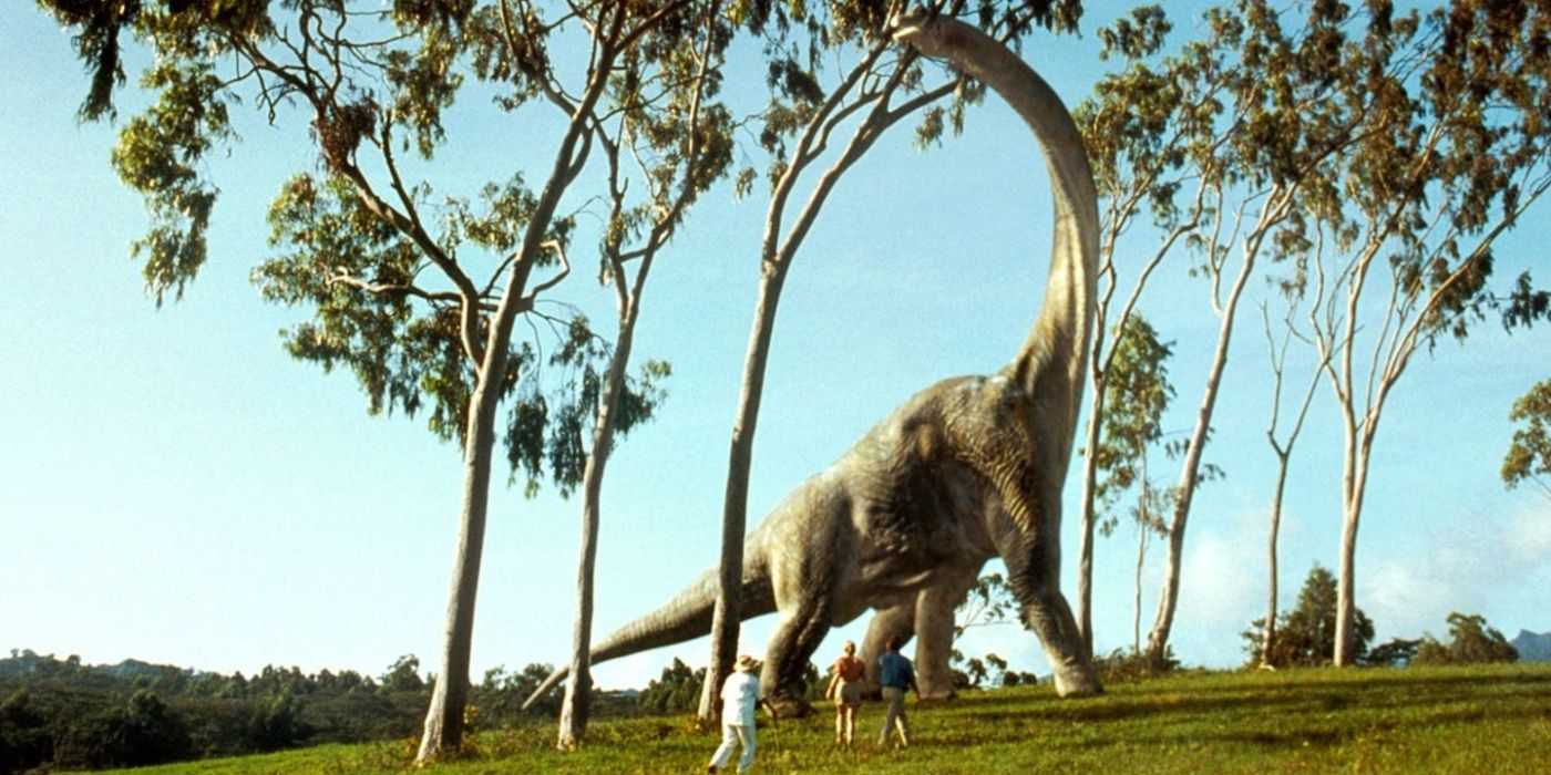 John Hammond, Ellie Satler y Alan Grant observando un braquiosaurio en Jurassic Park.