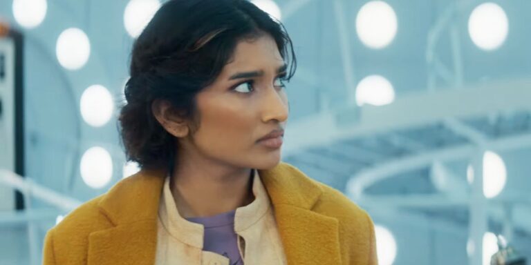 Varada Sethu con una chaqueta bronceada como compañera Belinda Chandra en la TARDIS en Doctor Who Season 2