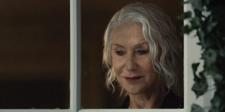 Maeve Harrigan in close -up looking through a window in the Mobland TV show on Paramount +.