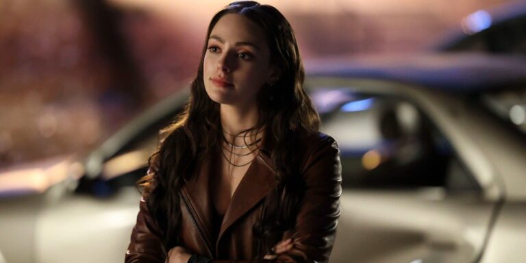 Espero que Mikaelson se vea sin amarre mientras se cruza con los brazos frente a un auto de herencia.