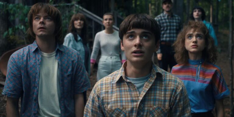 Jonathan, Will and Nancy stand in front of a group of people who seem to the sky on foreign things