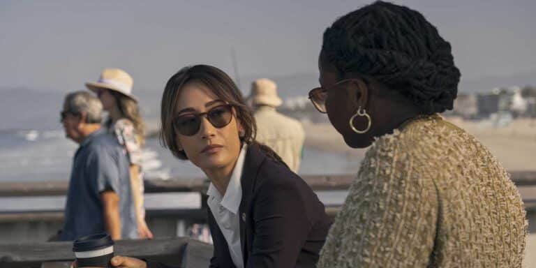 Renee Ballard, wearing a black suit and sunglasses, is next to Samira Parker in the Ballard TV show
